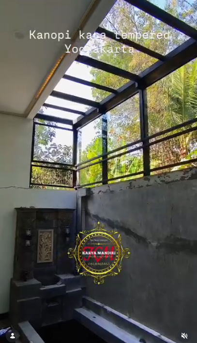 Proses pemasangan rangka besi berongga untuk atap kaca tempered.